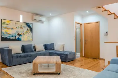 a living room with a blue couch and a table at Casa do Vasco in Porto