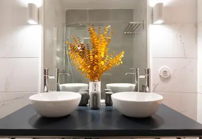 a bathroom with two sinks and a vase with yellow flowers at Historical Penthouse at Cardosas Block in Porto