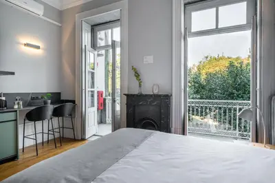 a bedroom with a large bed and a fireplace at Limehome Porto Rua de Dom Manuel II in Porto