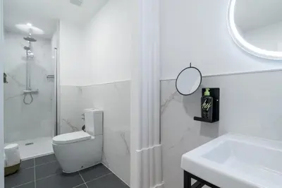 a bathroom with a toilet and a sink and a mirror at Limehome Porto Rua de Dom Manuel II in Porto