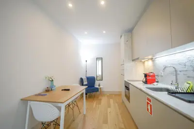 a kitchen with a sink and a table with chairs at Mártires Sweet Apts by PortoCityHosts in Porto