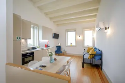 a kitchen and living room with a table and chairs at Mártires Sweet Apts by PortoCityHosts in Porto