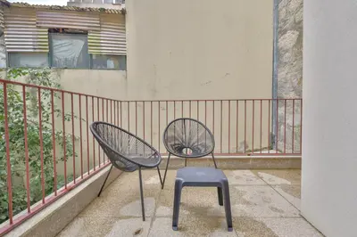 a chair and a stool sitting on a balcony at Mártires Sweet Apts by PortoCityHosts in Porto