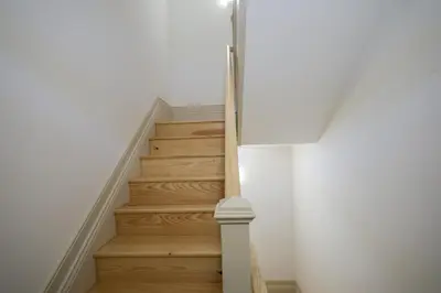 a staircase in a home with white walls and wooden floors at Mártires Sweet Apts by PortoCityHosts in Porto