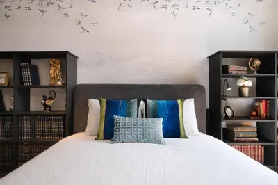 a bedroom with a bed with blue birds on the wall at Cardosas Gem - Historic ap 1F in Porto