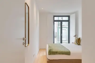 a white bedroom with a bed and a window at Alma da Casa by DA'HOME in Porto