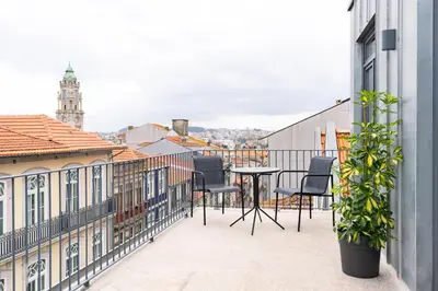 a balcony with chairs and a table on a building at Alma da Casa by DA'HOME in Porto