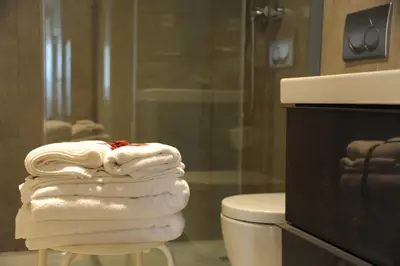 a stack of towels sitting on a stool in a bathroom at Capim Dourado Apartments Cedofeita in Porto