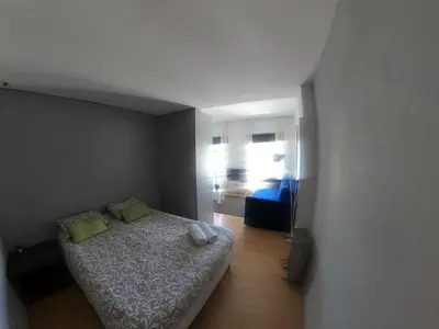 a small bedroom with a bed with two green pillows at Santa Catarina´s Soul in Porto