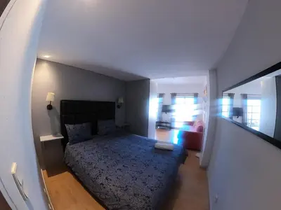 a bedroom with a bed with a blue comforter at Santa Catarina´s Soul in Porto
