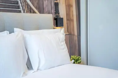 a bed with white pillows in a room at João IV Jewel Retreat by LovelyStay in Porto
