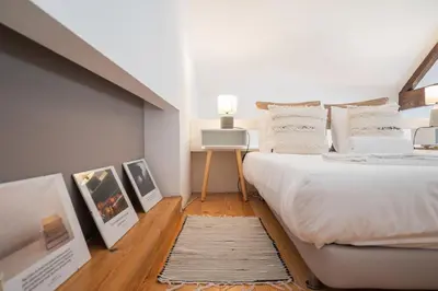 a bedroom with a white bed and a rug at Santo António Loft - Porto Perfect in Porto