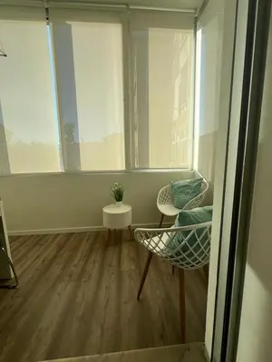 a room with a chair and a table and two windows at Acquamarina Porto in Porto