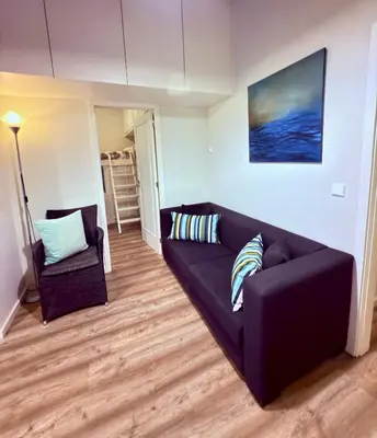 a living room with a black couch and a chair at Acquamarina Porto in Porto