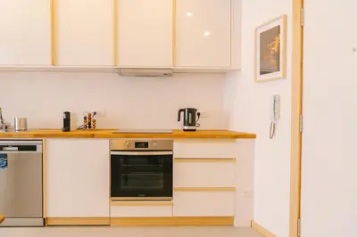 a kitchen with white cabinets and a black appliance at Porto Serenity loft. in Porto