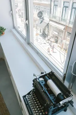 an open window with a typewriter on a window sill at Porto Serenity loft. in Porto