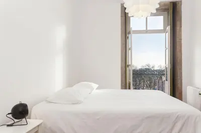 a bedroom with a white bed and a window at Belly Angel Apartment in Porto
