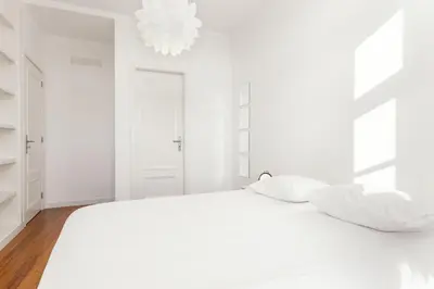 a white bedroom with a white bed and a chandelier at Belly Angel Apartment in Porto