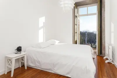 a white bedroom with a white bed and a window at Belly Angel Apartment in Porto
