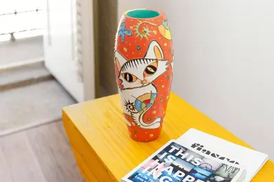 a vase sitting on a table next to a magazine at Hungarian Biscuits Historic Center in Porto