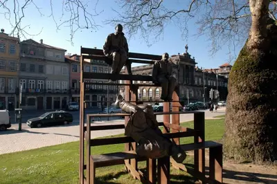 a statue of two people sitting on a bench at Hungarian Biscuits Historic Center in Porto