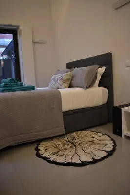 a bedroom with a bed with a rug on the floor at JM Alojamento local no Porto in Porto