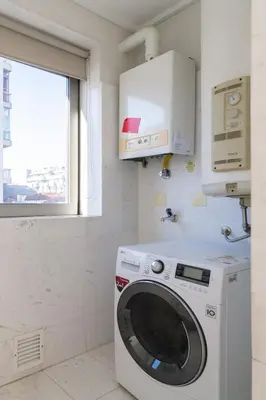 a washing machine in a bathroom with a window at Host Wise - Gorgeous Spacious Flat - Ace Location in Porto