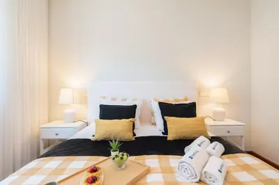 a bedroom with a large white bed with pillows at Host Wise - Gorgeous Spacious Flat - Ace Location in Porto