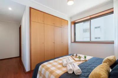 a bedroom with a bed and a large window at Host Wise - Gorgeous Spacious Flat - Ace Location in Porto