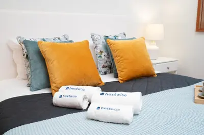 a bed with orange and blue pillows on it at Host Wise - Gorgeous Spacious Flat - Ace Location in Porto