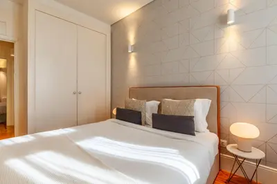 a bedroom with a large white bed with two pillows at D&S - Alvares Cabral in Porto