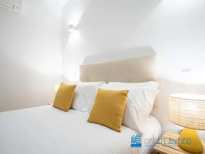 a bedroom with a white bed with yellow pillows at Porto Almada Design Loft in Porto
