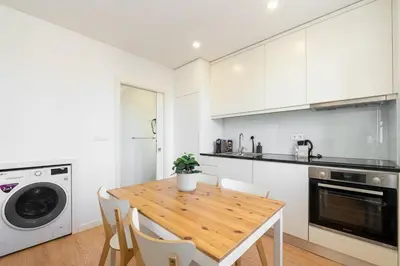 a kitchen with a wooden table and white cabinets at GuestReady - King House 2 in Porto