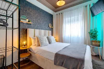 a bedroom with a large bed with blue curtains at Quiet Point in Porto