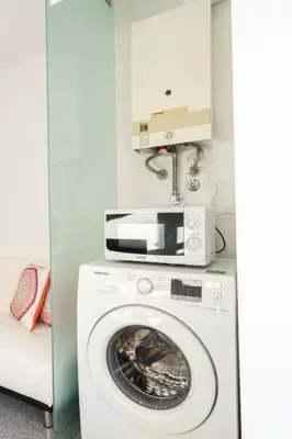 a washer and dryer with a microwave above it at Host Wise - Comfy Charming Flat w Netflix - Ace Location in Porto
