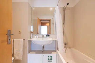a white bathroom with a sink and a bath tub at Host Wise - Comfy Charming Flat w Netflix - Ace Location in Porto