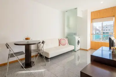 a living room with a white couch and a table at Host Wise - Comfy Charming Flat w Netflix - Ace Location in Porto