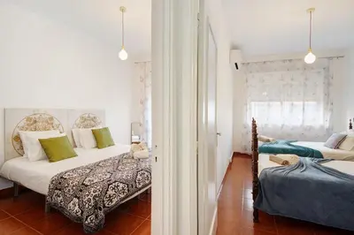 a bedroom with two beds and a window at Trindade Porto City Centre in Porto