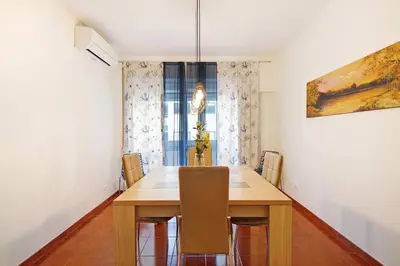 a dining room with a wooden table and chairs at Trindade Porto City Centre in Porto