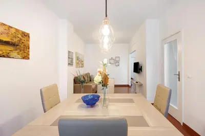 a dining room with a table with a vase of flowers at Trindade Porto City Centre in Porto