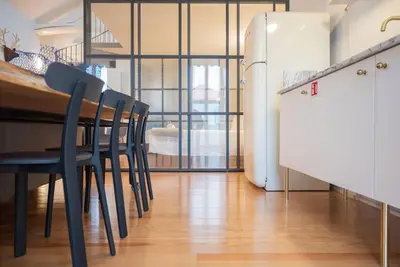 a kitchen with a table and chairs and a refrigerator at Charmy Studio Porto in Porto