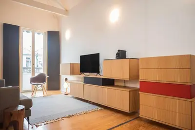 a living room with a flat screen tv on a wall at Charmy Studio Porto in Porto