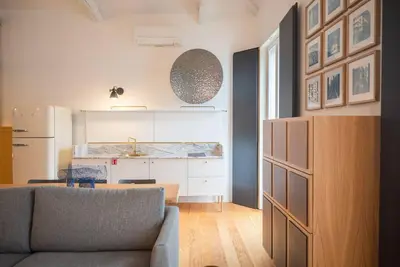a living room with a couch and a kitchen at Charmy Studio Porto in Porto