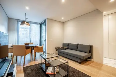 a living room with a couch and a table at Primrose 1BR Delight w Parking by LovelyStay in Porto