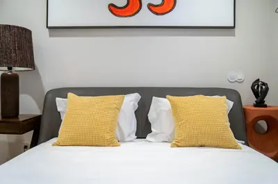 a bedroom with a bed with yellow and white pillows at Primrose 1BR Delight w Parking by LovelyStay in Porto
