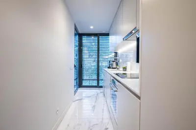 a white kitchen with white counters and a window at Primrose 1BR Delight w Parking by LovelyStay in Porto