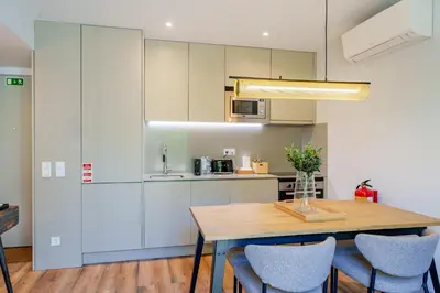 a kitchen with a wooden table and chairs at Feel Porto Firmeza Coworking & Flats in Porto