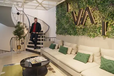 a man standing on a staircase in a living room at Feel Porto Firmeza Coworking & Flats in Porto
