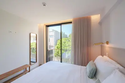 a bedroom with a bed and a large window at Feel Porto Firmeza Coworking & Flats in Porto