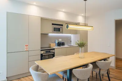 a kitchen with a wooden table and chairs at Feel Porto Firmeza Coworking & Flats in Porto